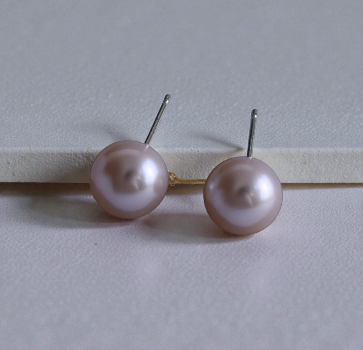 S925 silver pearl earrings photographed on stone