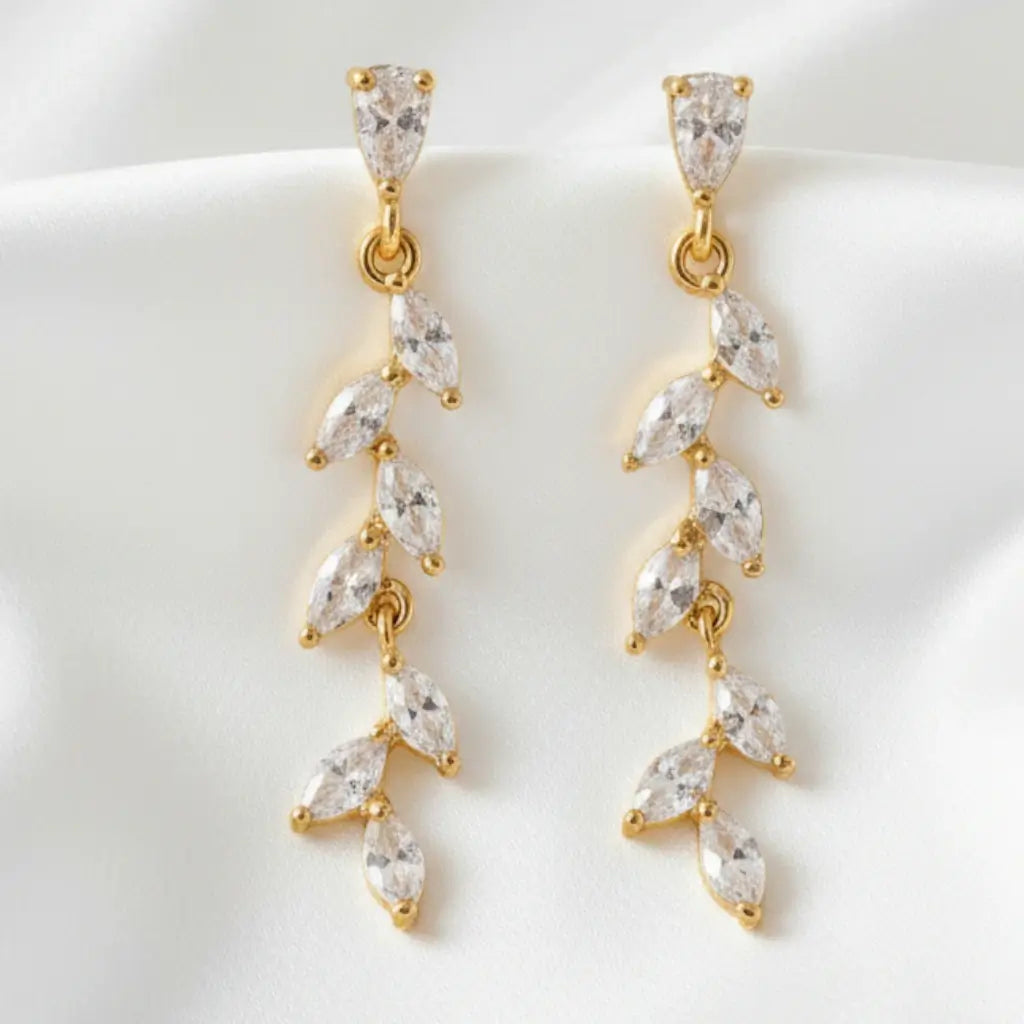 Gold and clear crystal drop earrings on a white background
