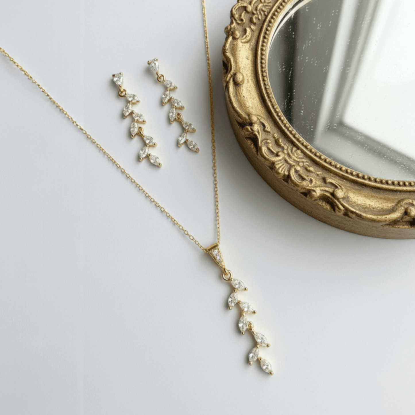 Gold marquise‑cut bridal earrings photographed on soft white background