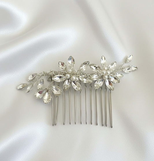 Bride sitting in front of a mirror with soft natural lighting, preparing her hair for a wedding look