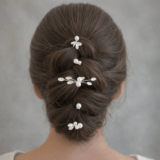 Bridal low bun hairstyle decorated with pearl and crystal hair pins.