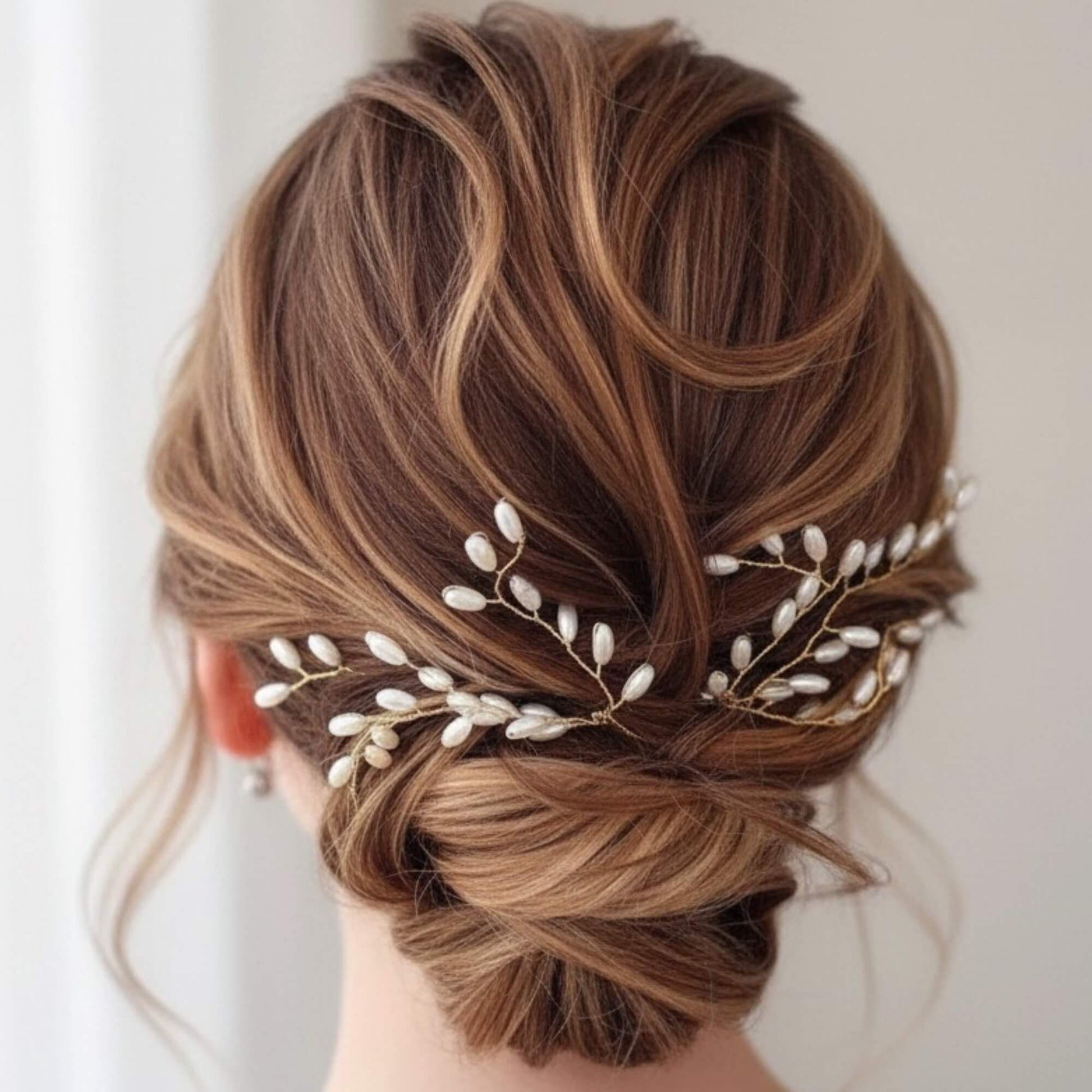 Bride wearing a gold bridal hair pin placed in a romantic half‑up hairstyle.