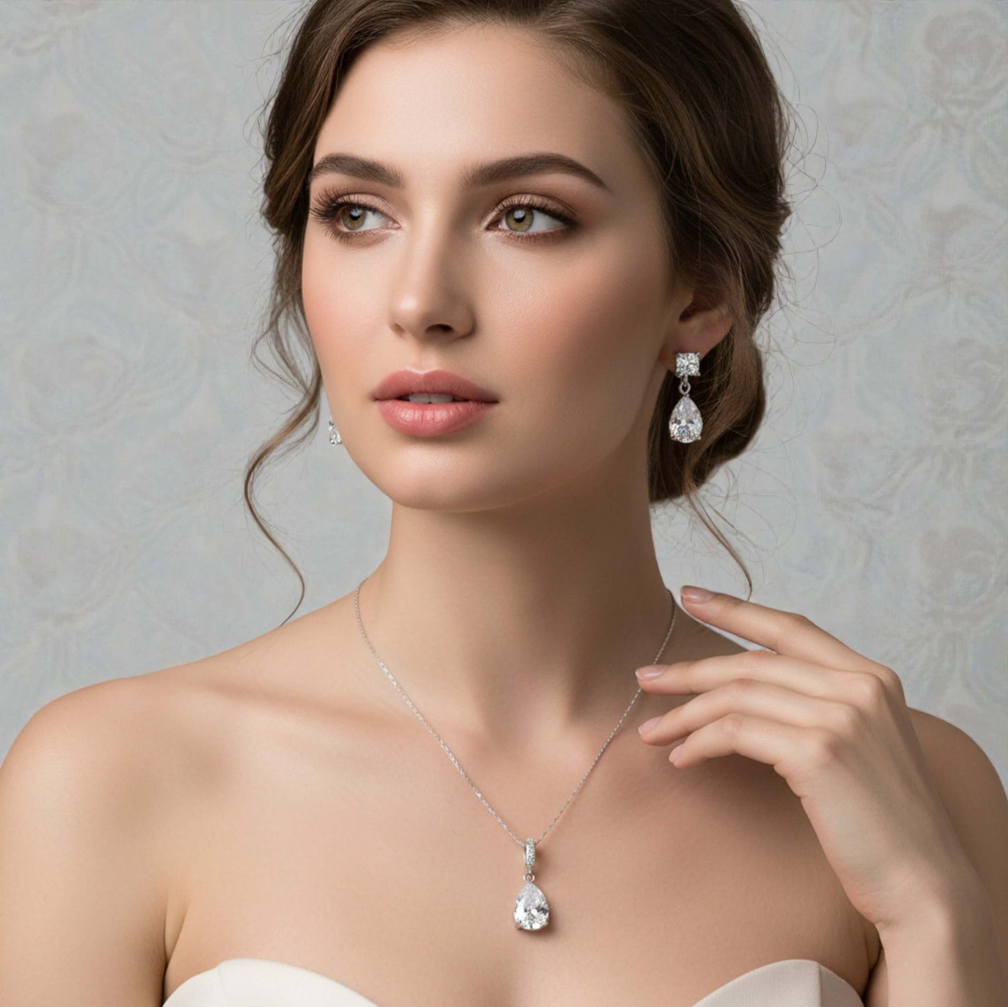 Woman wearing a necklace and earrings against a neutral background