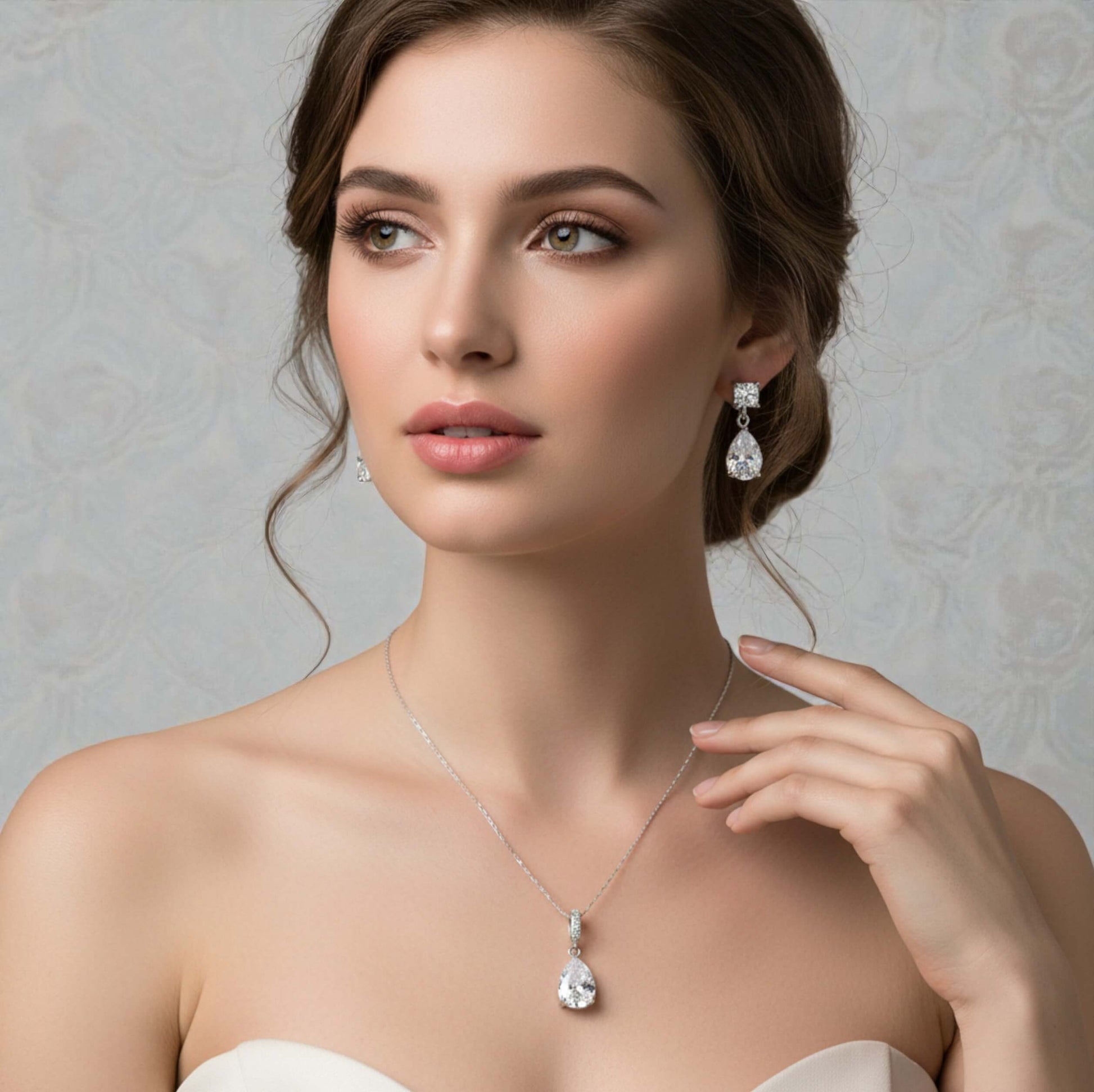 Woman wearing a necklace and earrings against a neutral background