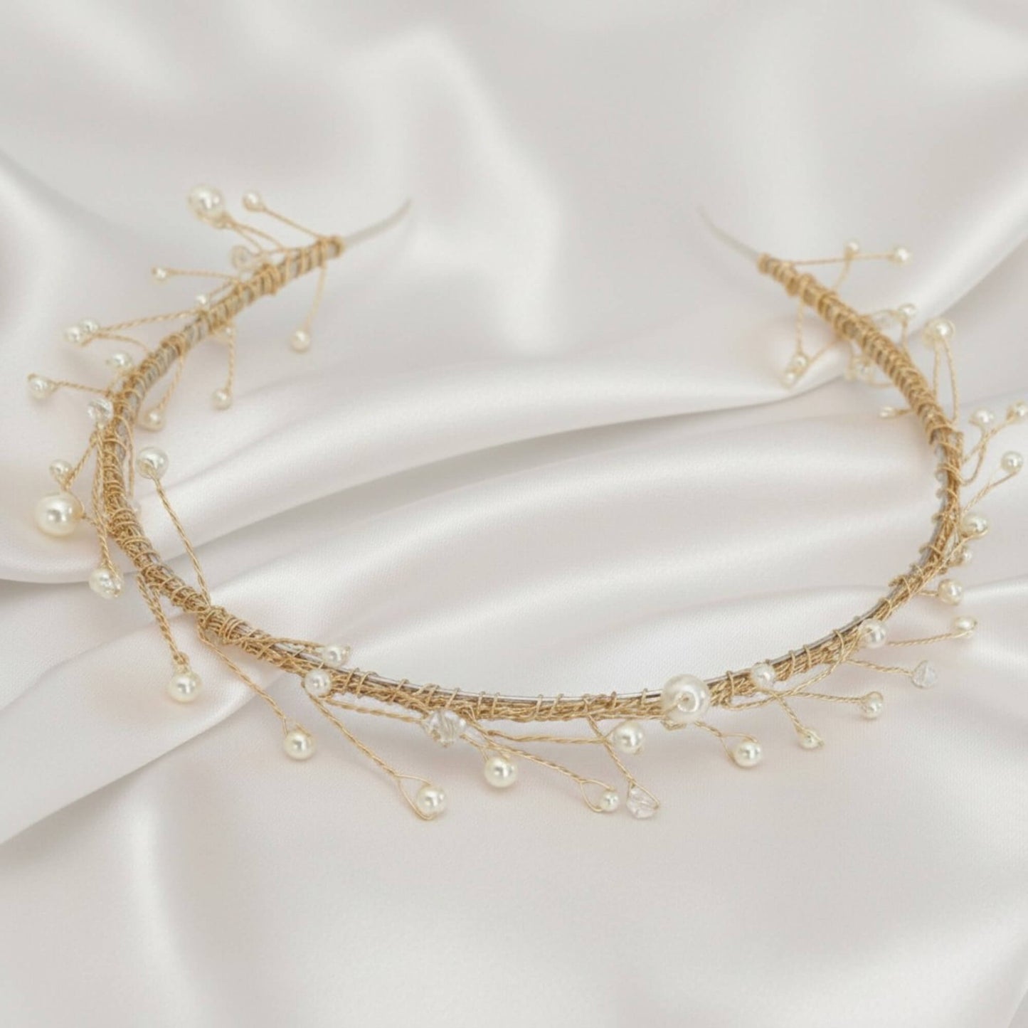 Delicate rose‑gold bridal hairvine with white pearls and clear crystals on white satin.