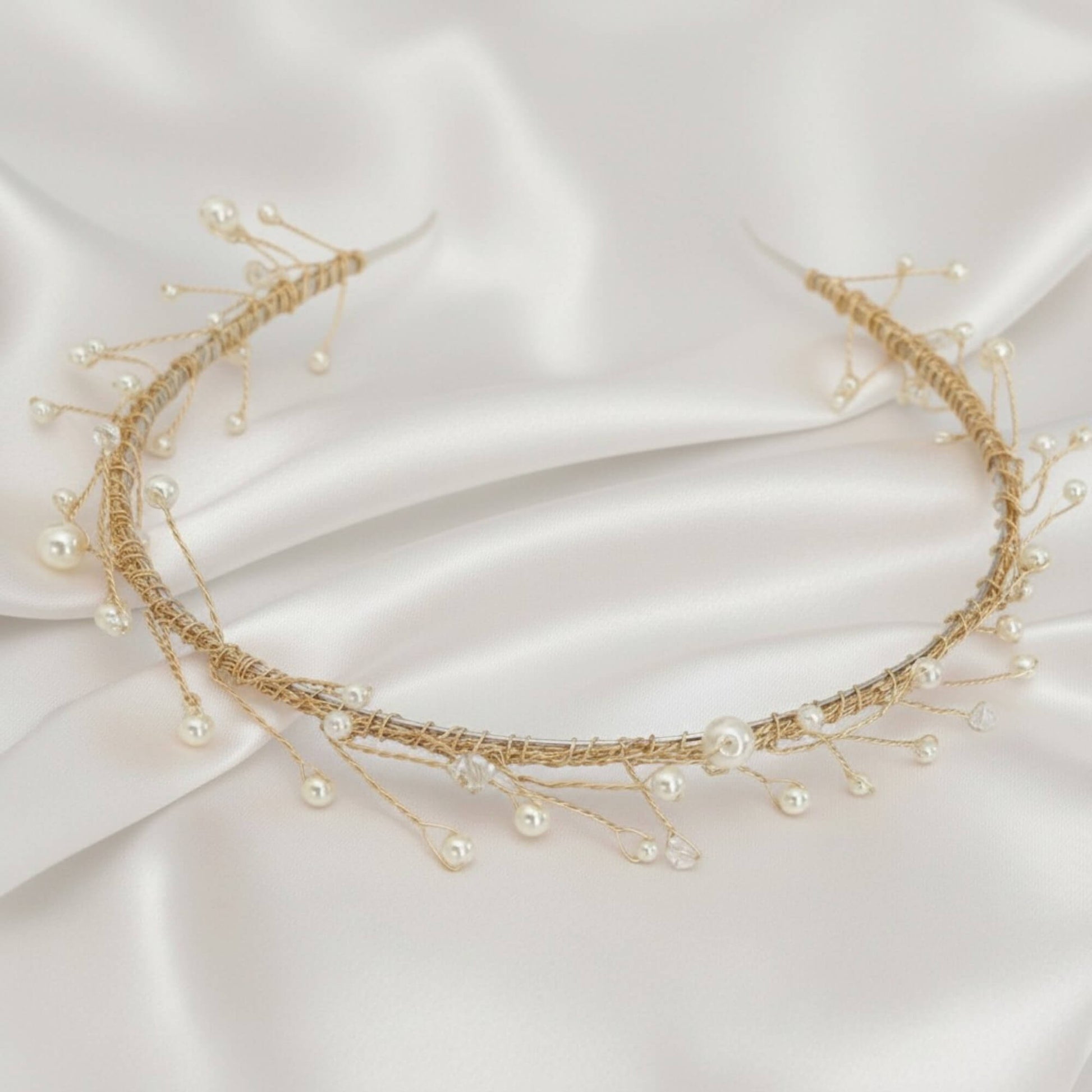 Delicate rose‑gold bridal hairvine with white pearls and clear crystals on white satin.