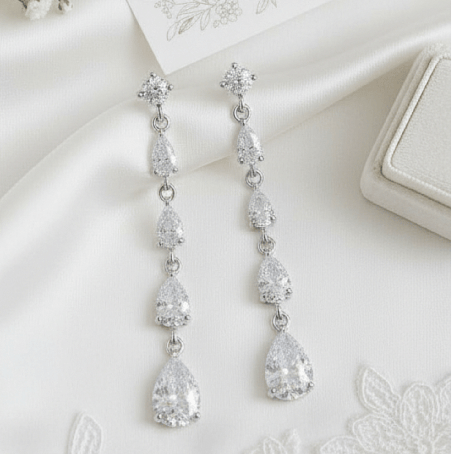 Silver teardrop earrings on a white surface