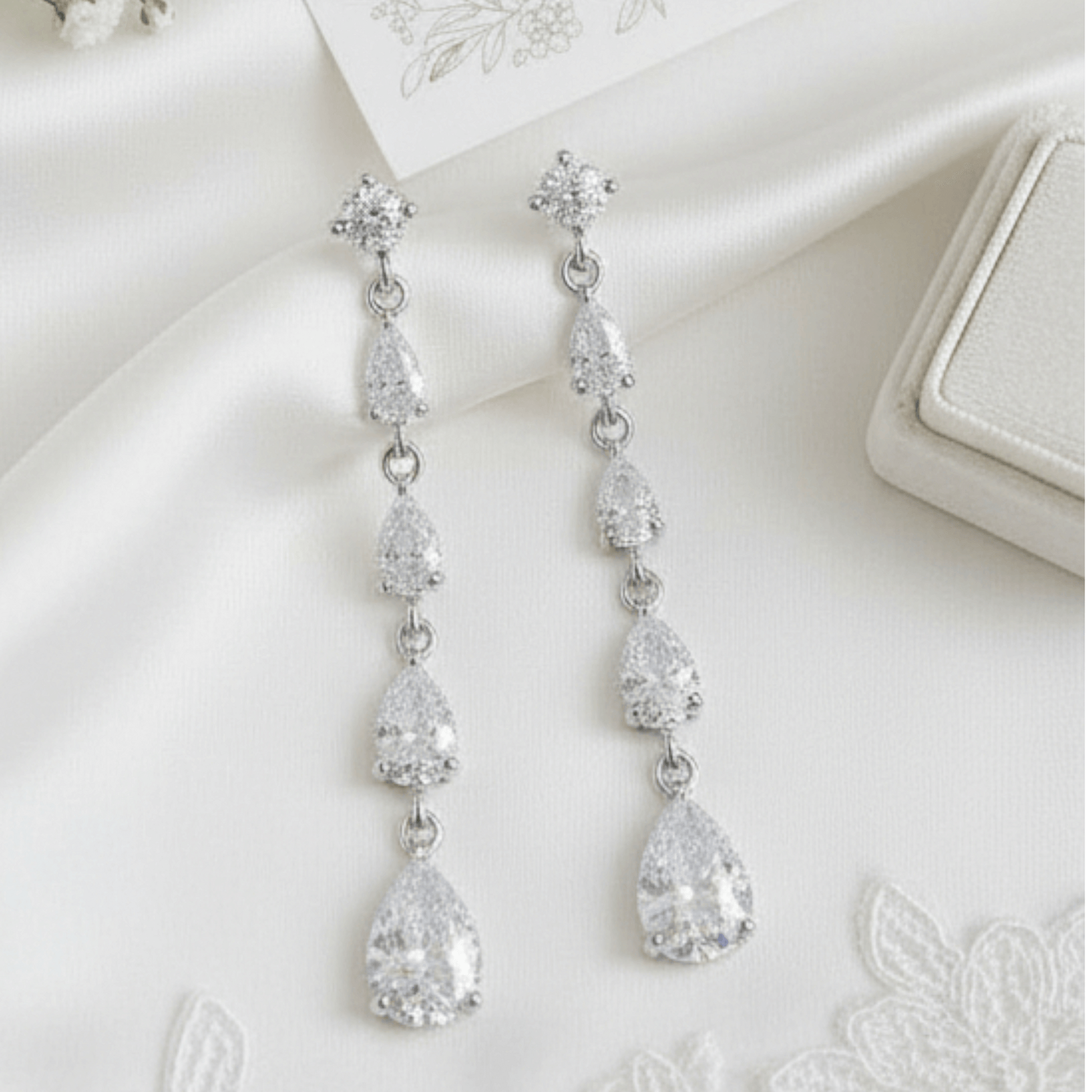 Silver teardrop earrings on a white surface