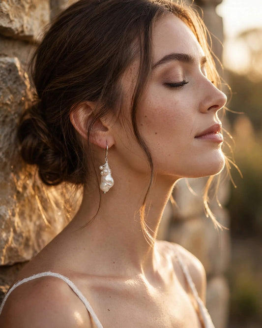 bride wearing baroque pearl dangle earrings with sterling silver hook in elegant low bun hairstyle