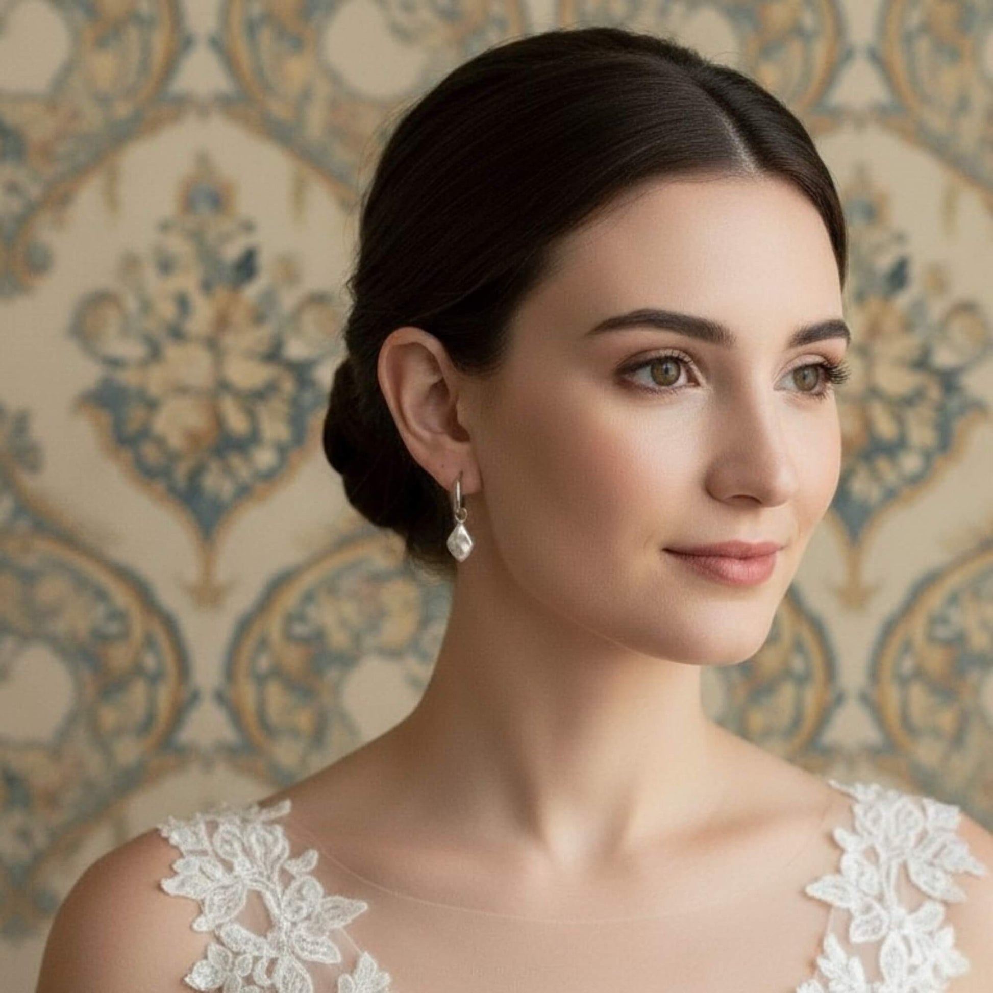Side view of bride showing silver hoop earrings with ivory geometric pendant, refined and modern bridal mood.