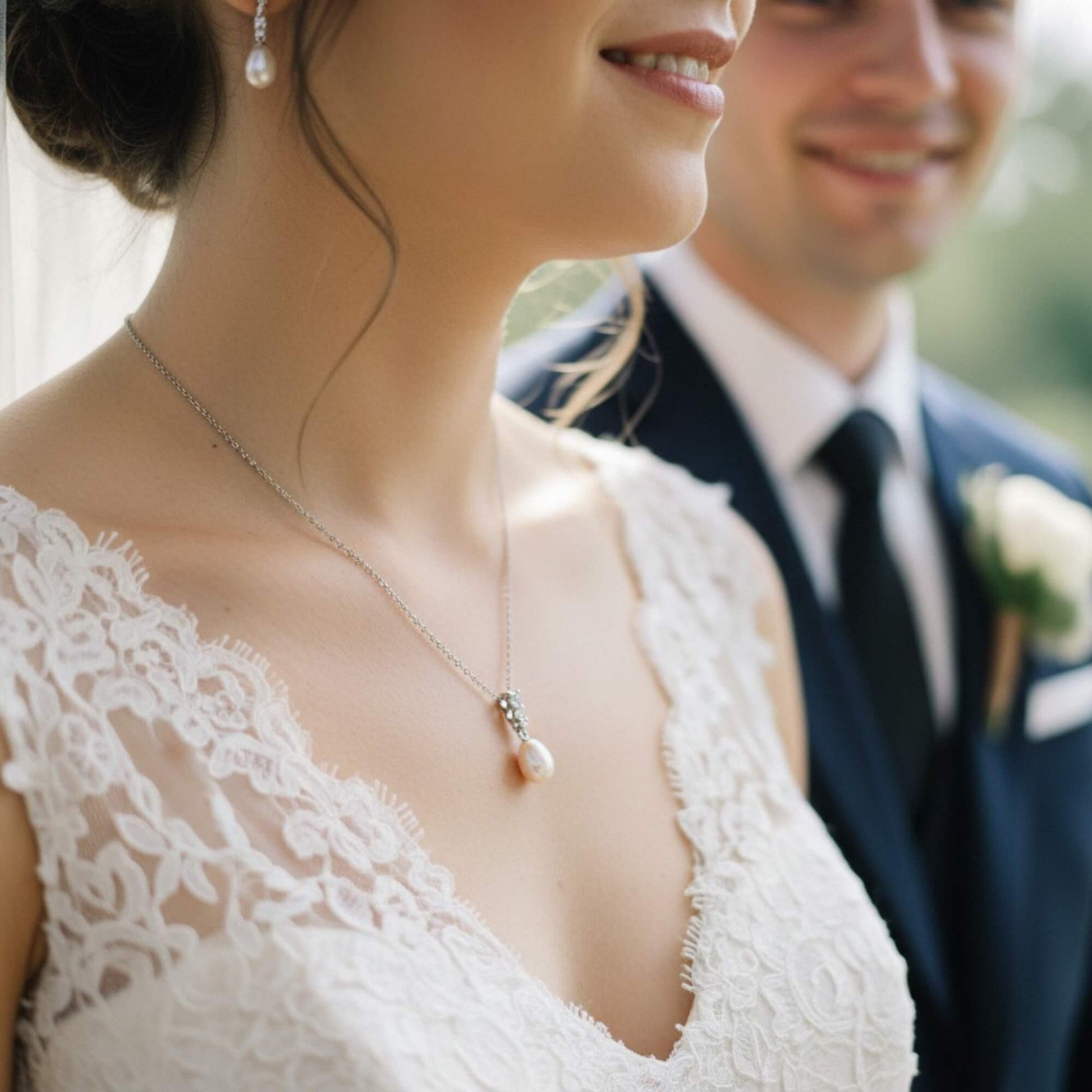 Close‑up of bride wearing gold pearl pendant necklace with crystal accents, soft romantic bridal mood, Australia
