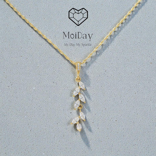 14K gold leaf pendant photographed on textured grey