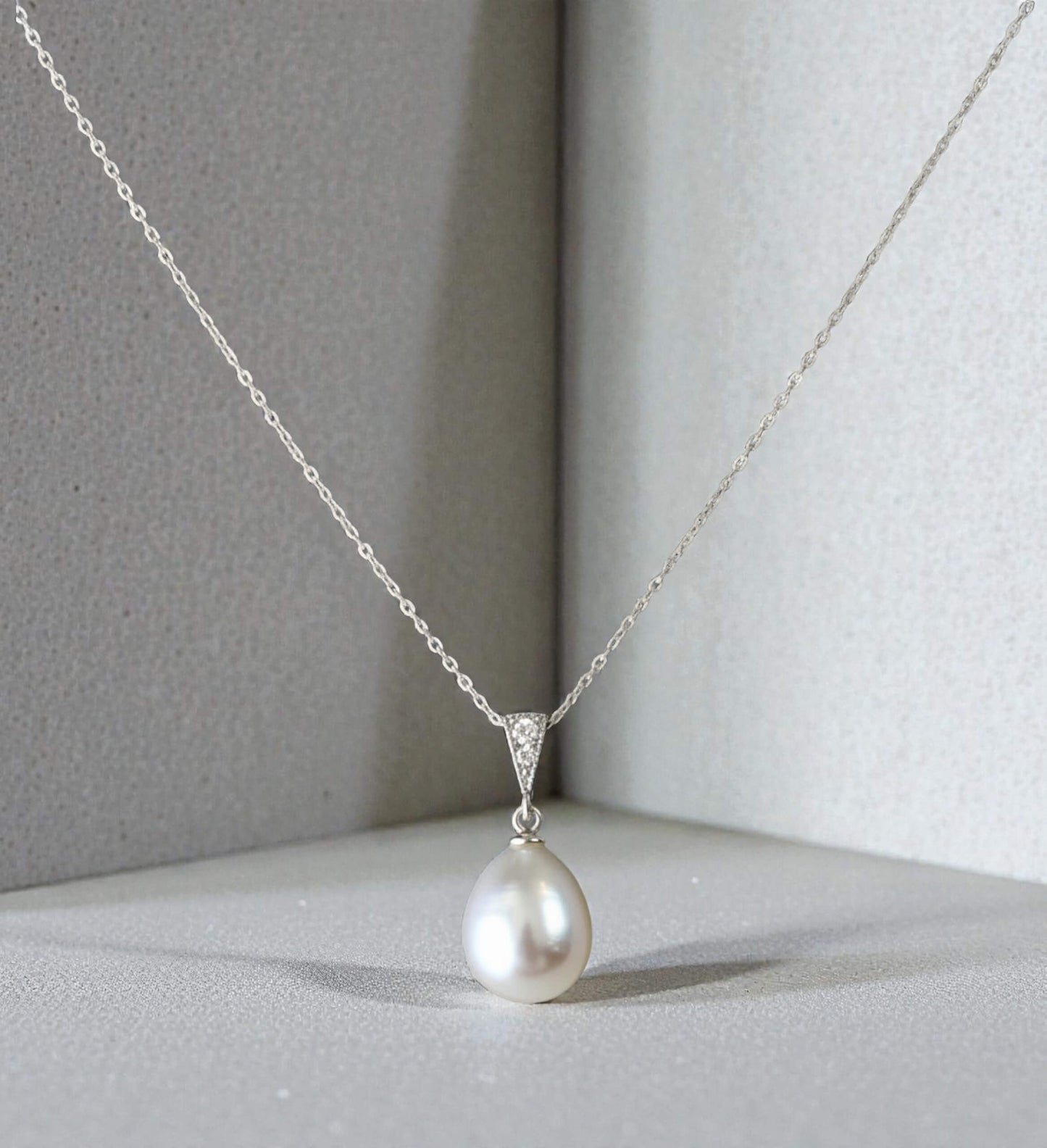 gold-plated freshwater pearl pendant necklace photographed on light satin surface