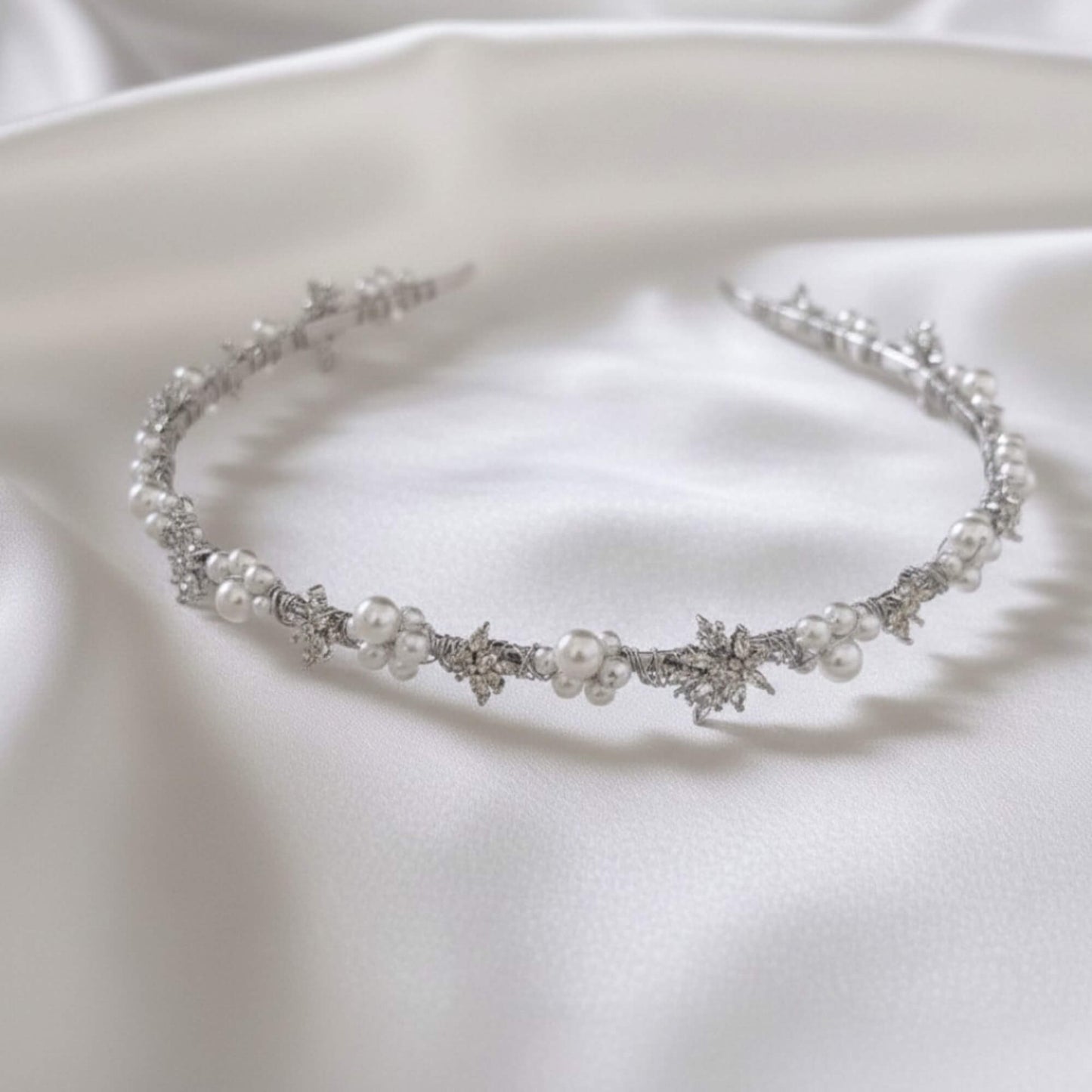 Silver pearl and zircon headband styled on minimal satin backdrop