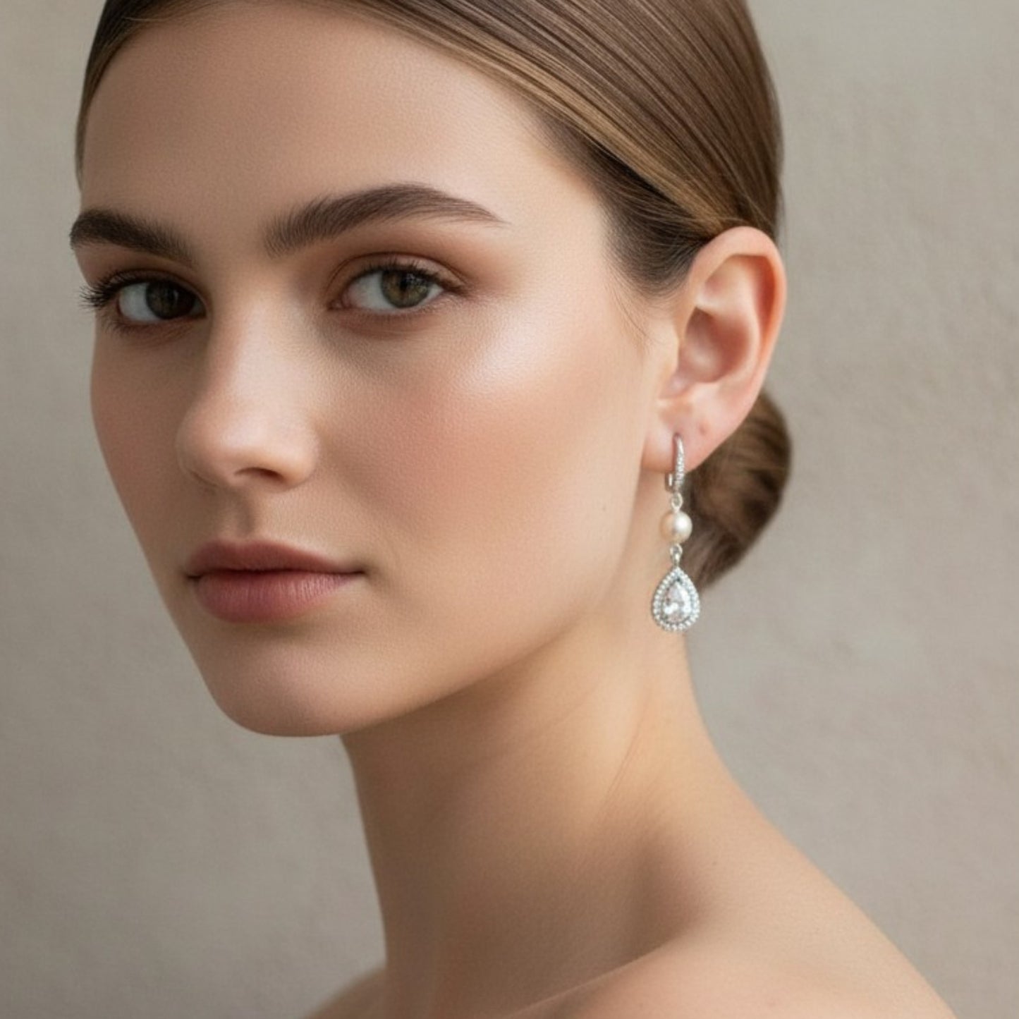 Side profile of bride showing pearl and crystal teardrop earrings, minimal makeup and soft bridal mood.