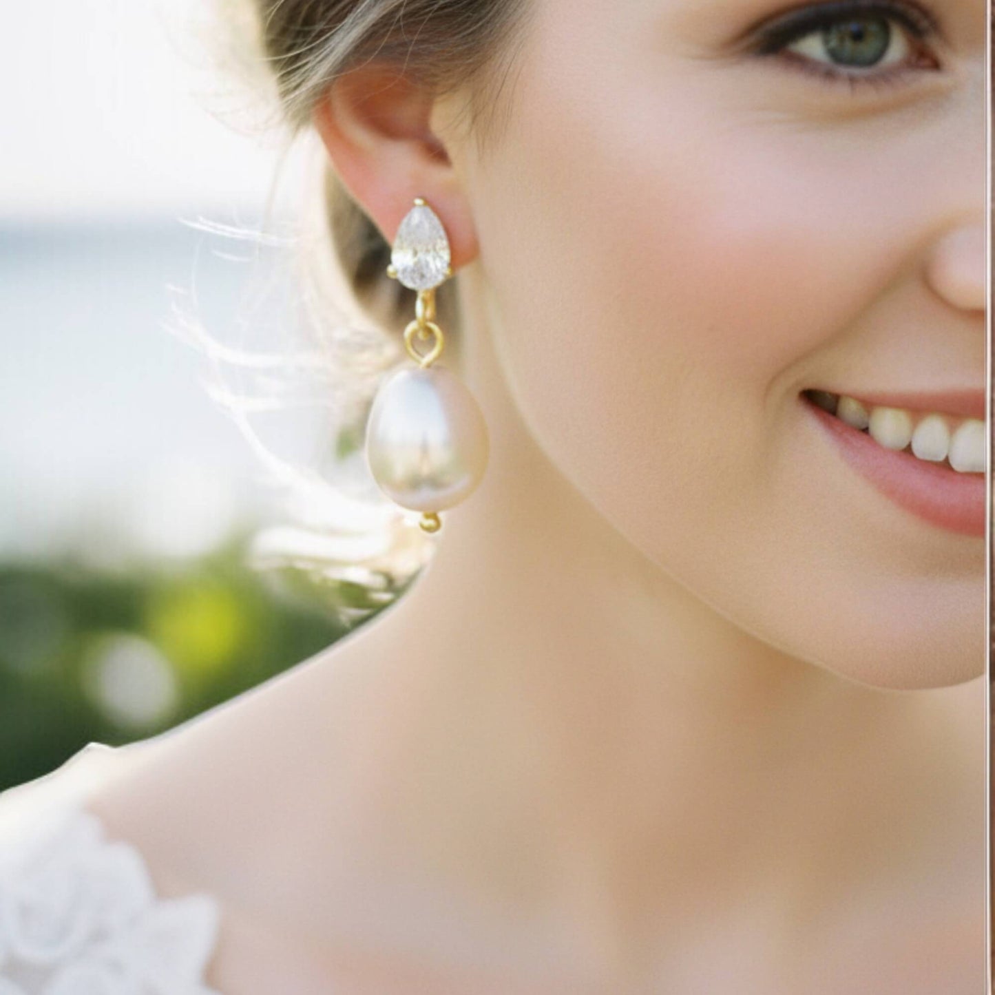 Close-up of a woman wearing elegant earrings with a blurred outdoor background