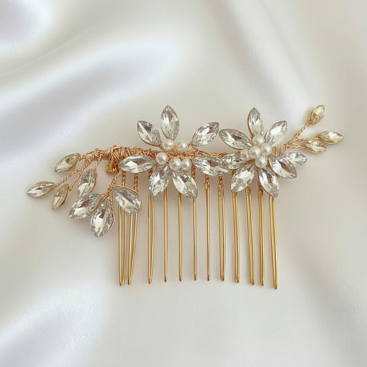 Stylist placing a crystal floral hair comb onto a loose boho bridal braid.