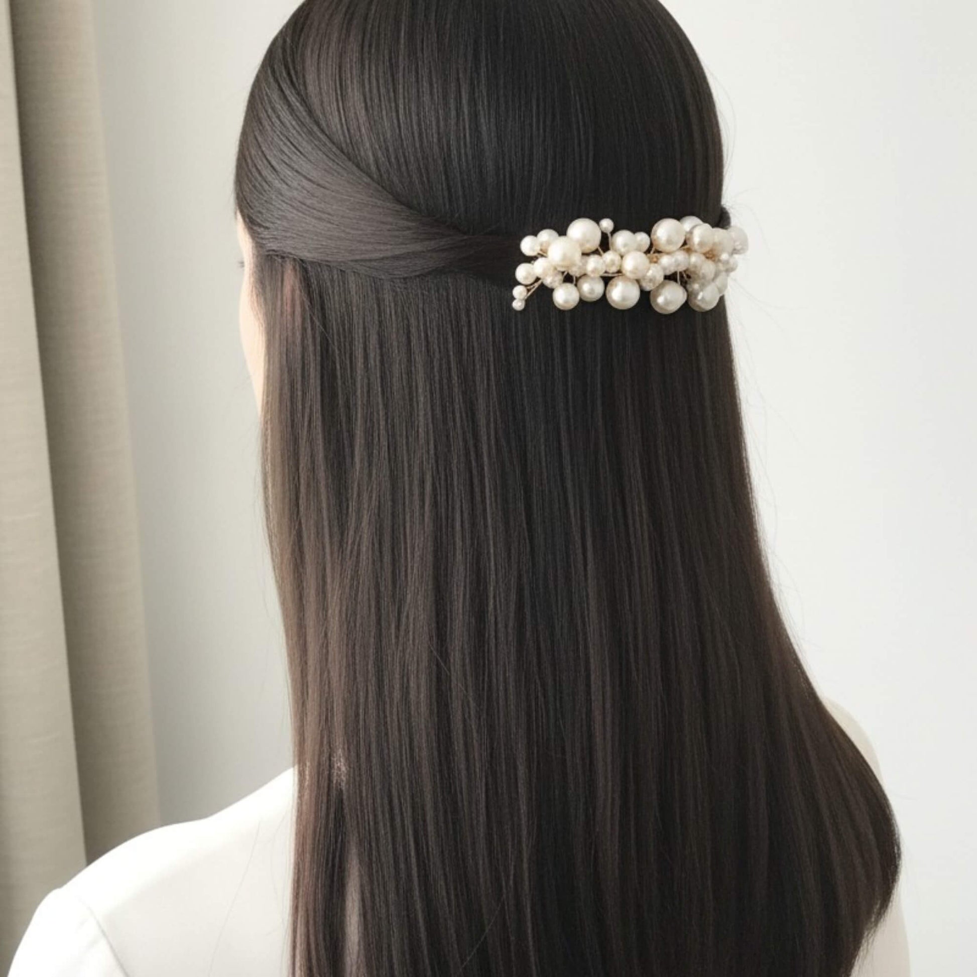 bride wearing a pearl hair accessory against a neutral background