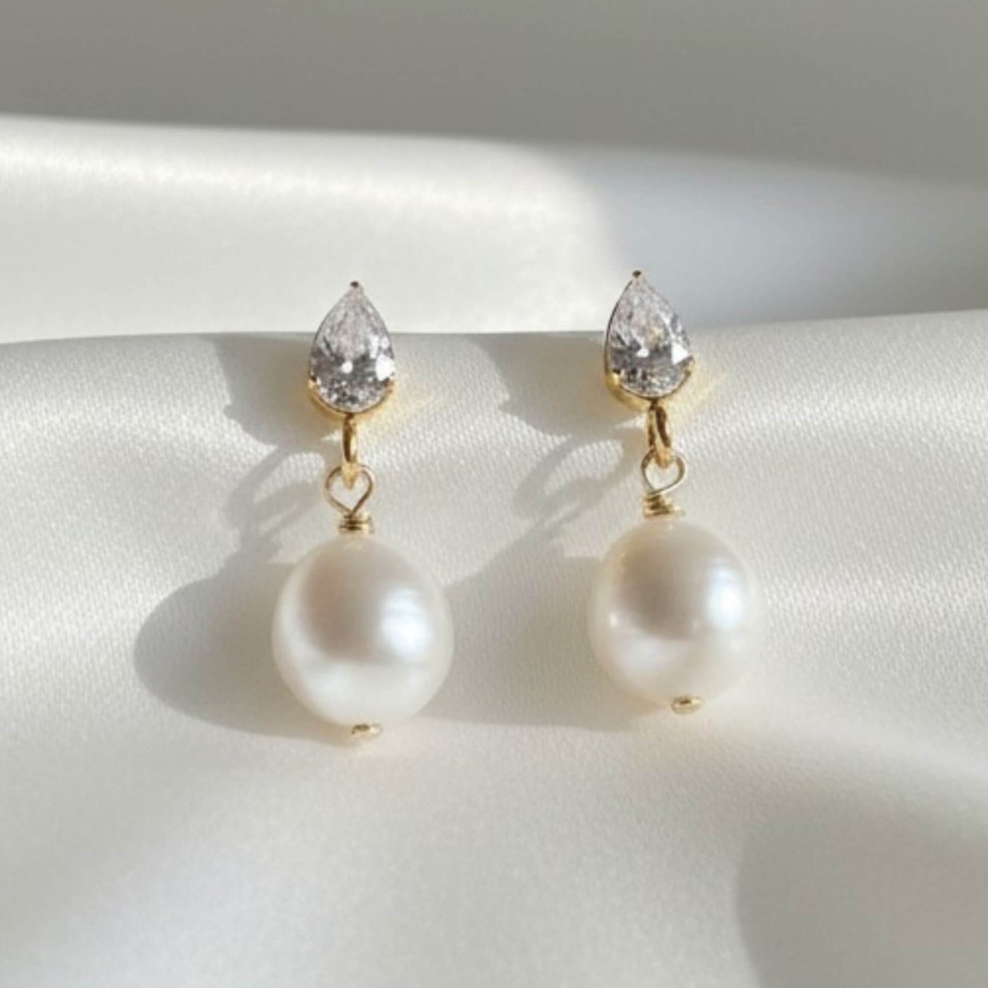 earl and crystal bridal earrings photographed on soft satin background, crisp details, luxury finish
