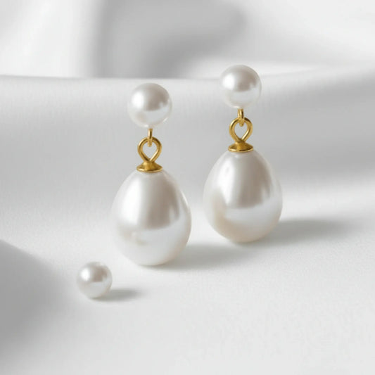 Pearl earrings with gold hooks on a light background