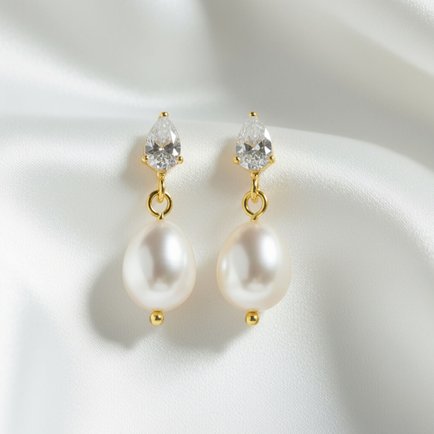 Pearl earrings with gold accents on a white background