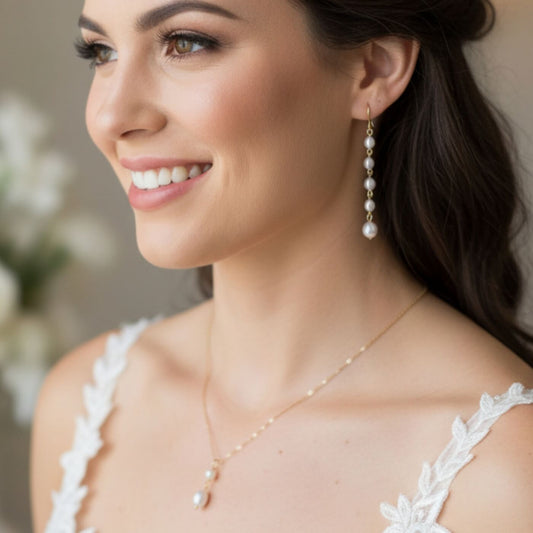 Woman wearing pearl earrings and necklace, smiling with a blurred background