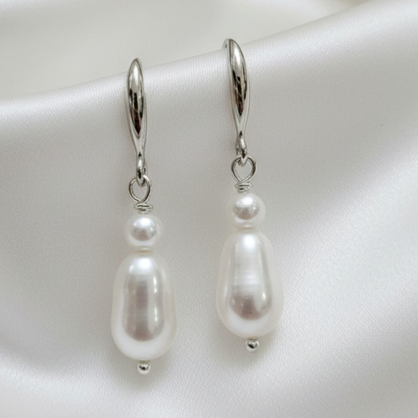 S925 silver elegant drop earrings photographed on white satin cloth