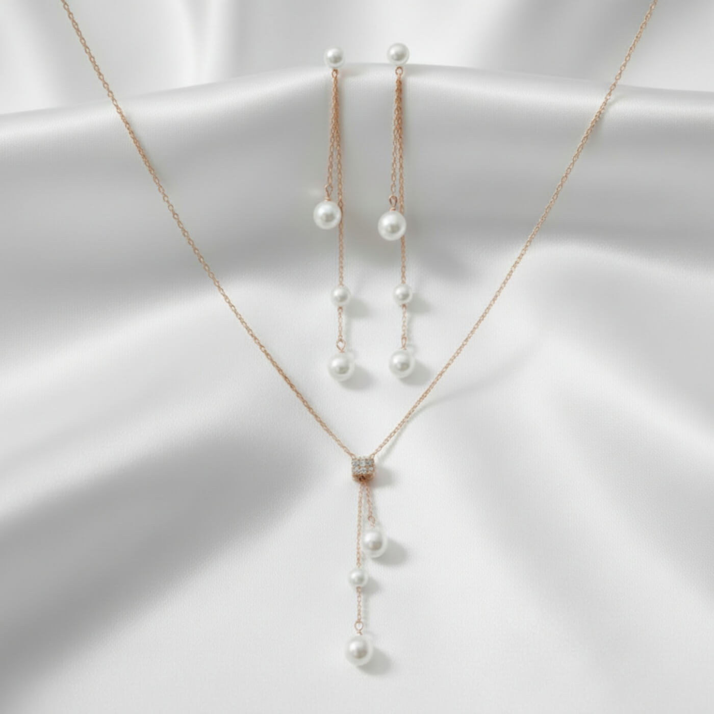 Pearl necklace and earrings on a white fabric background