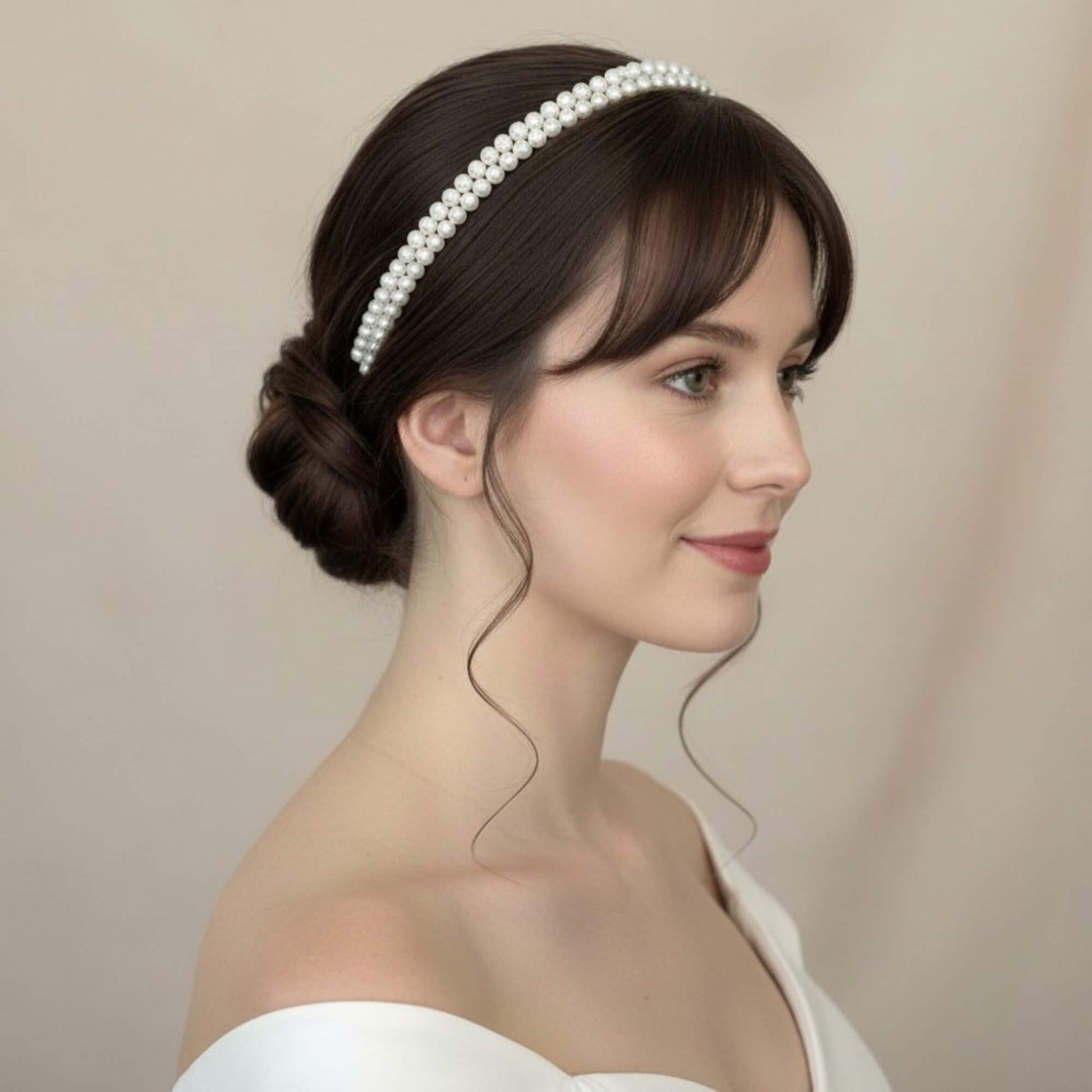 Bride wearing a double‑row soft‑white pearl headband styled with a sleek low bun.