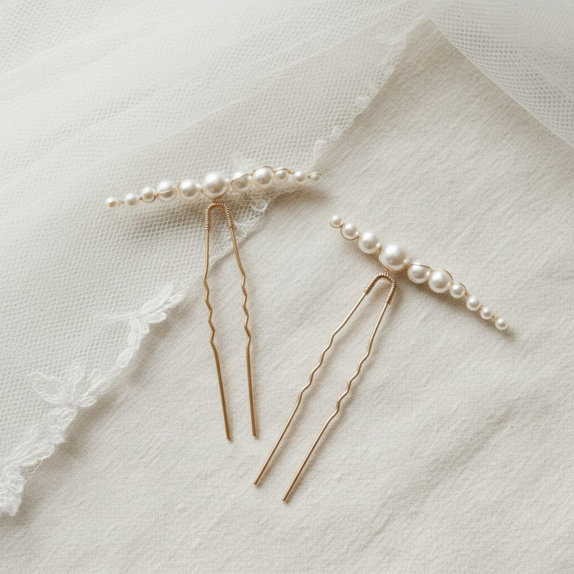 Close-up of gold bridal hair pin showing fine wire branches and pearl clusters.