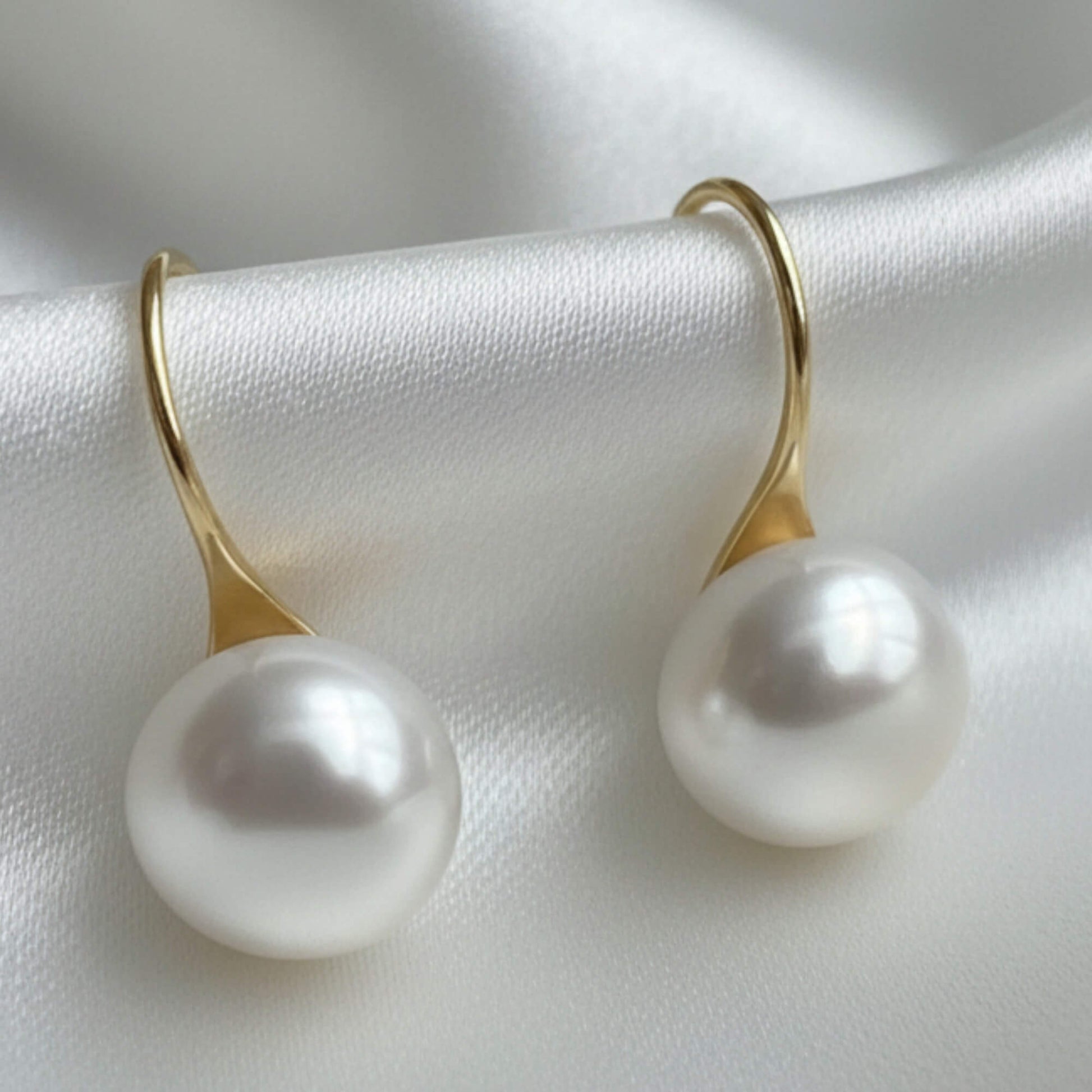 S925 silver pearl drop photographed on white satin fabric