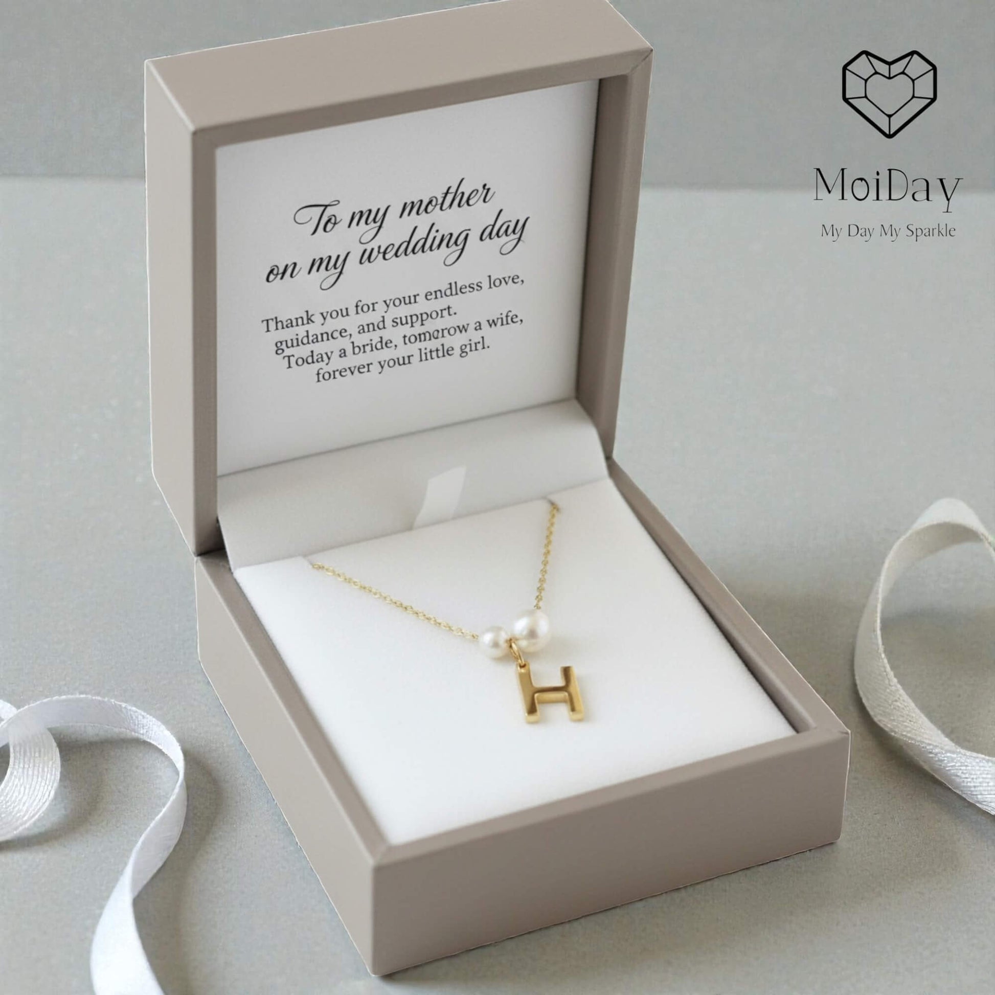 Gold necklace with a letter 'H' pendant in a gift box with a message, branded 'MoiDay'.