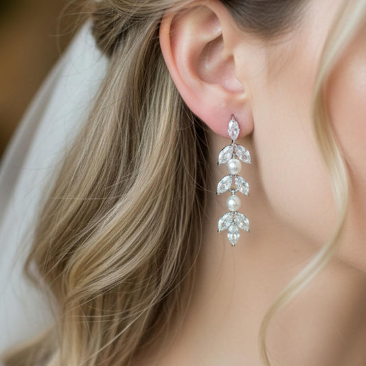 Close-up of a woman wearing elegant earrings with a soft background