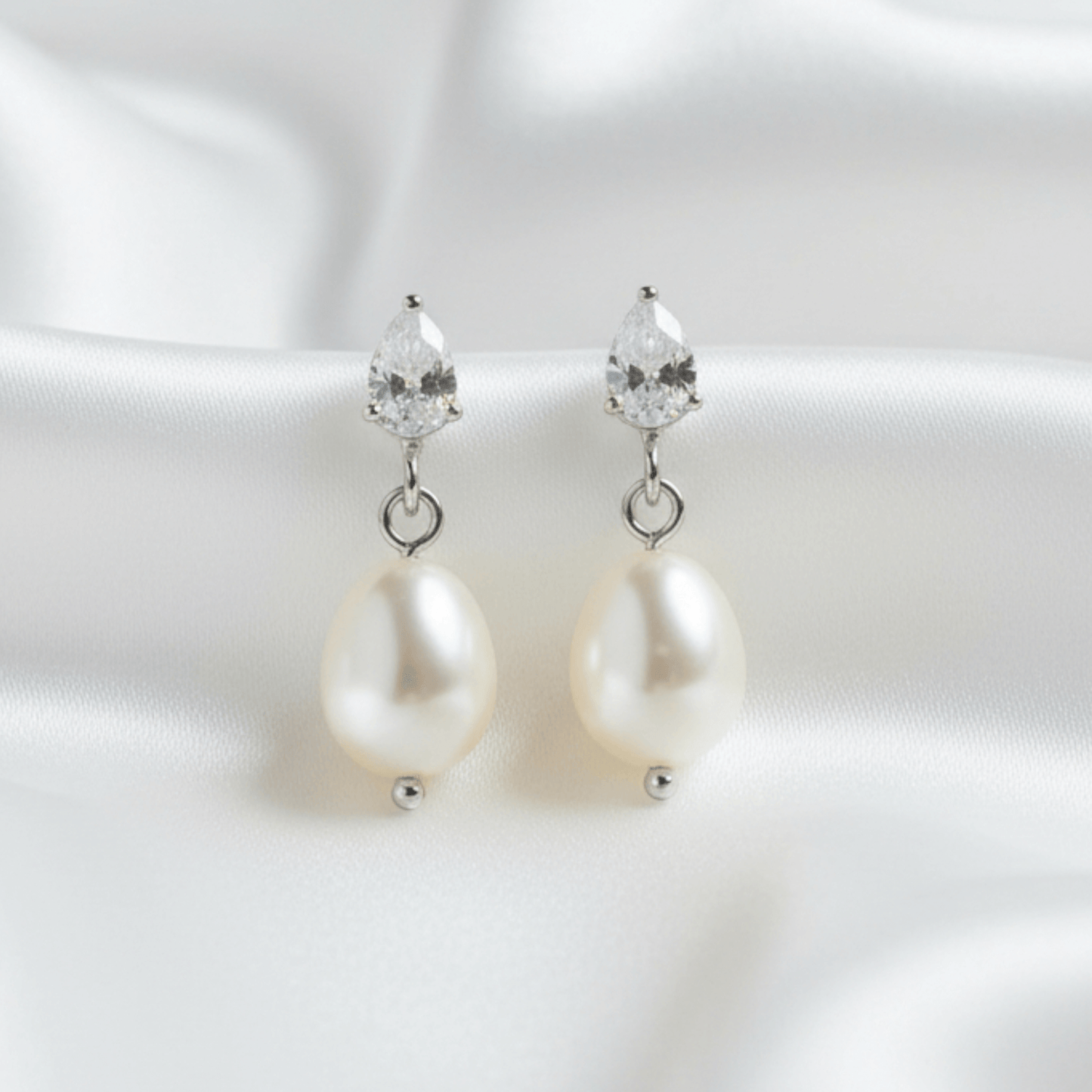 Pearl earrings with crystal drops on a white background