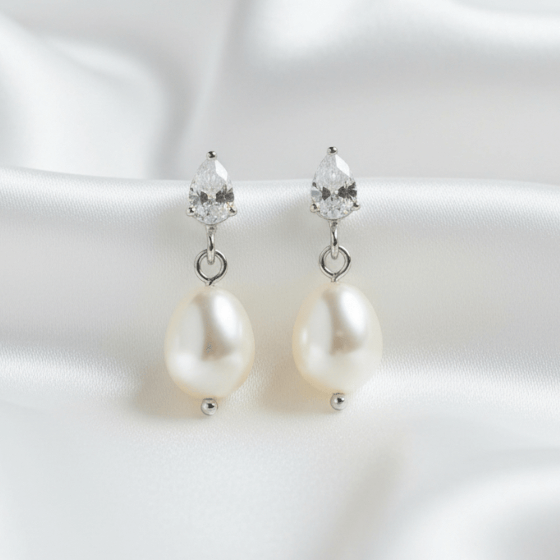 Pearl earrings with crystal drops on a white background