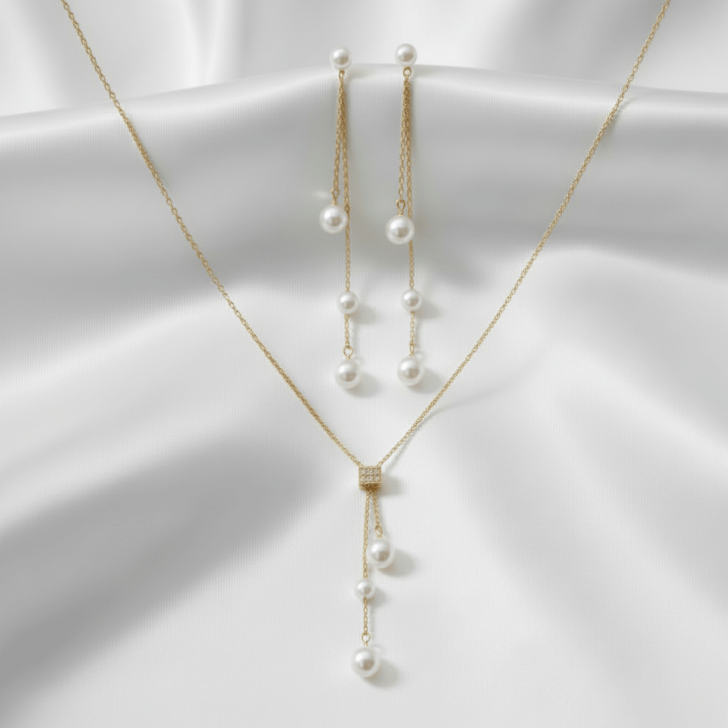 Gold necklace with pearl pendants on a white background