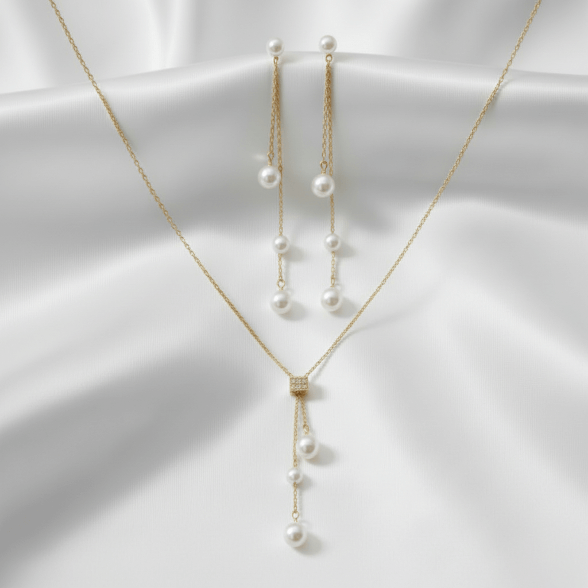 Gold necklace with pearl pendants on a white background