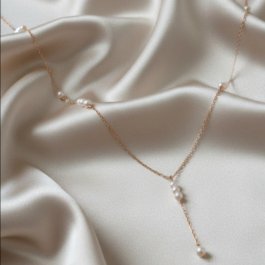Sterling silver pearl drop necklace photographed on a white marble stand
