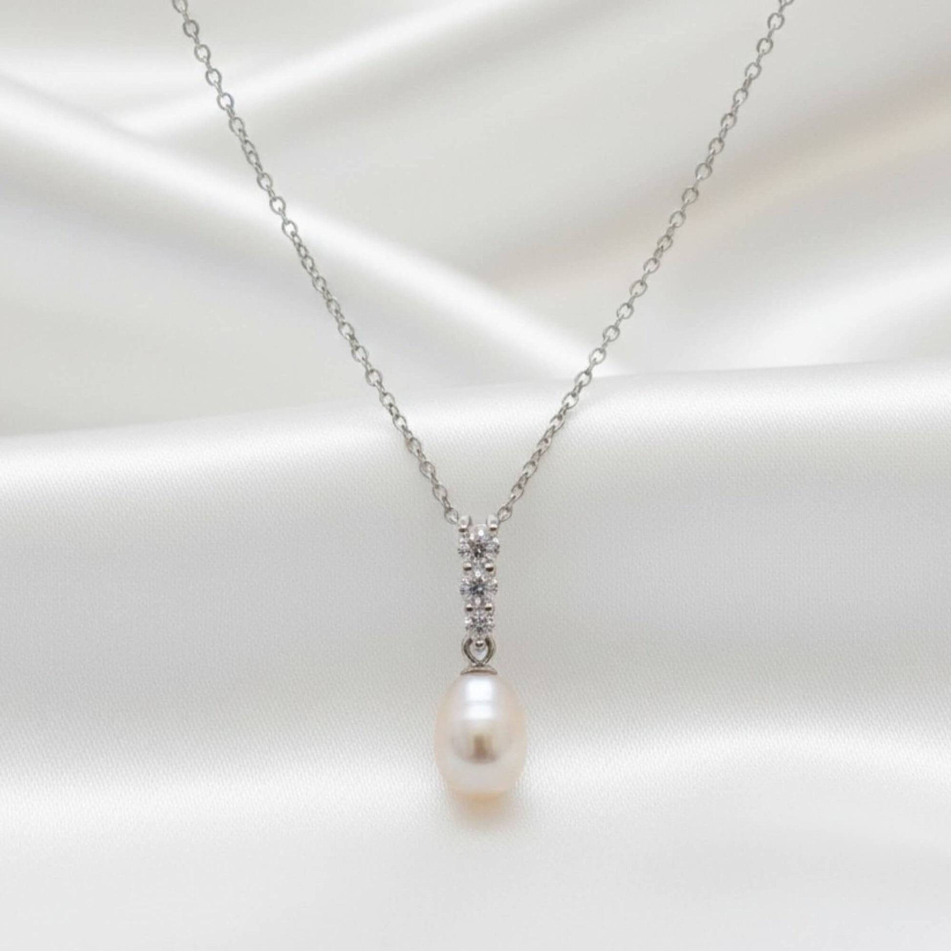 Silver freshwater pearl necklace with gemstone cluster shown in detailed product shot on soft white background, Australian bridal accessory.
