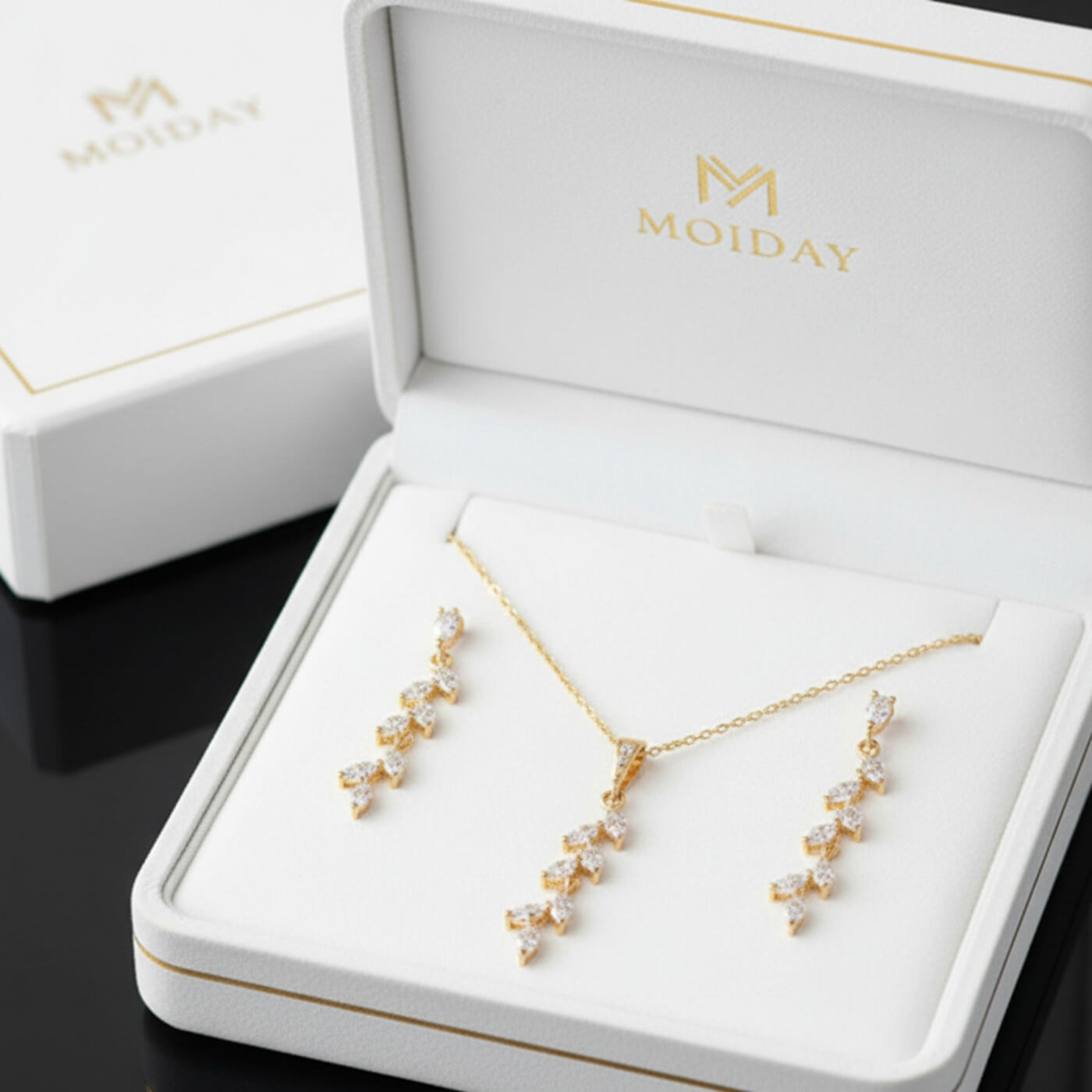 Gold leaf drop earrings photographed on MoiDay box