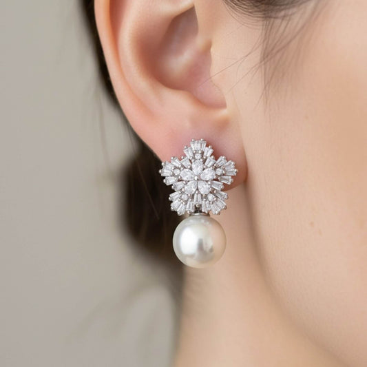 Bride wearing pearl drop earrings with crystal cluster in natural daylight.