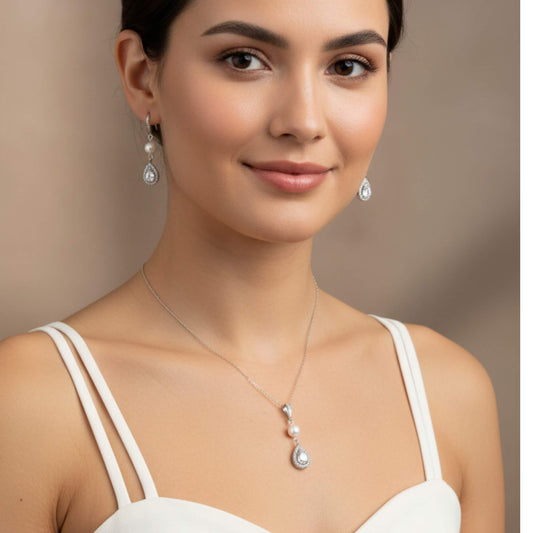 Woman wearing a bridal necklace and earrings with a neutral background