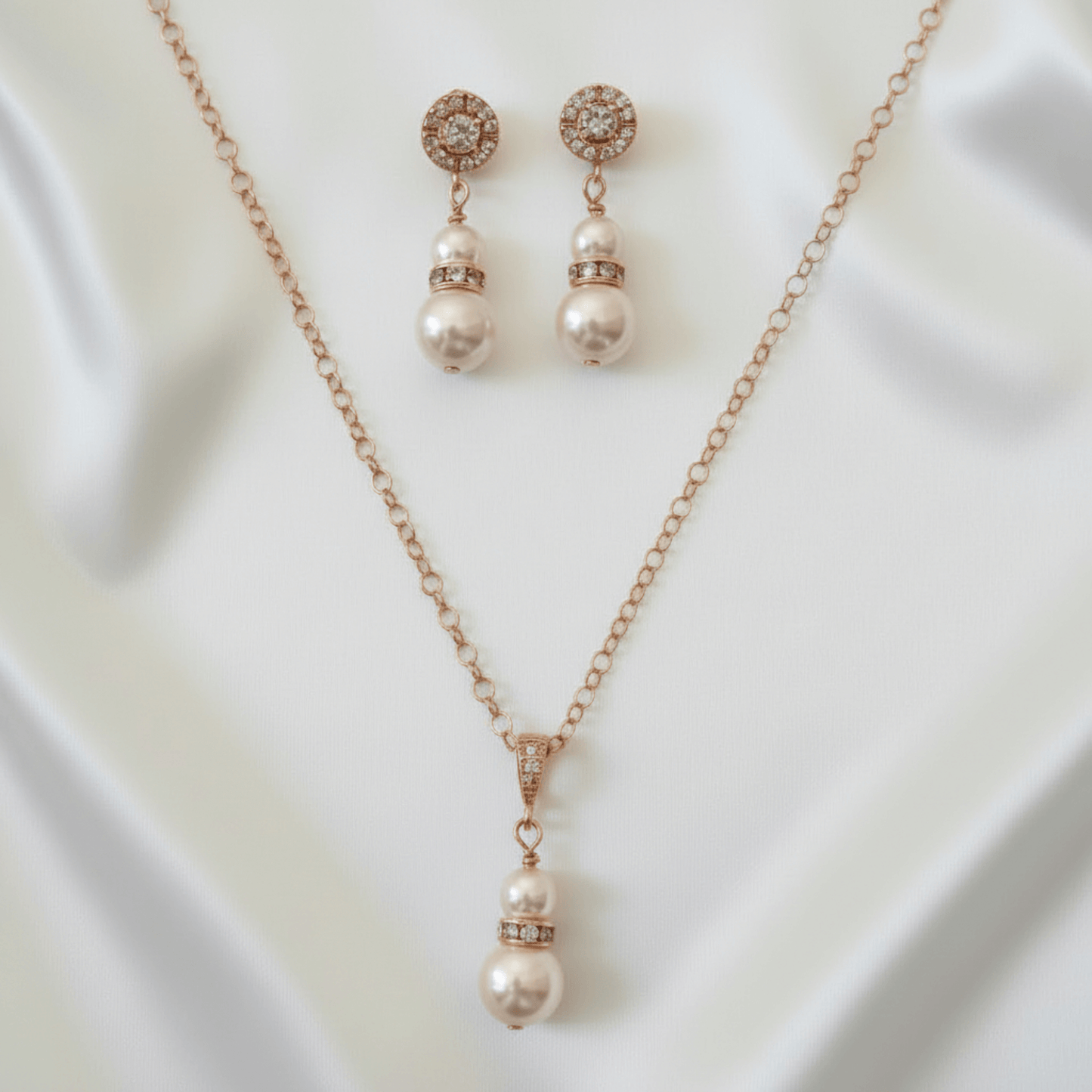 Pearl necklace and earrings set on a white fabric background