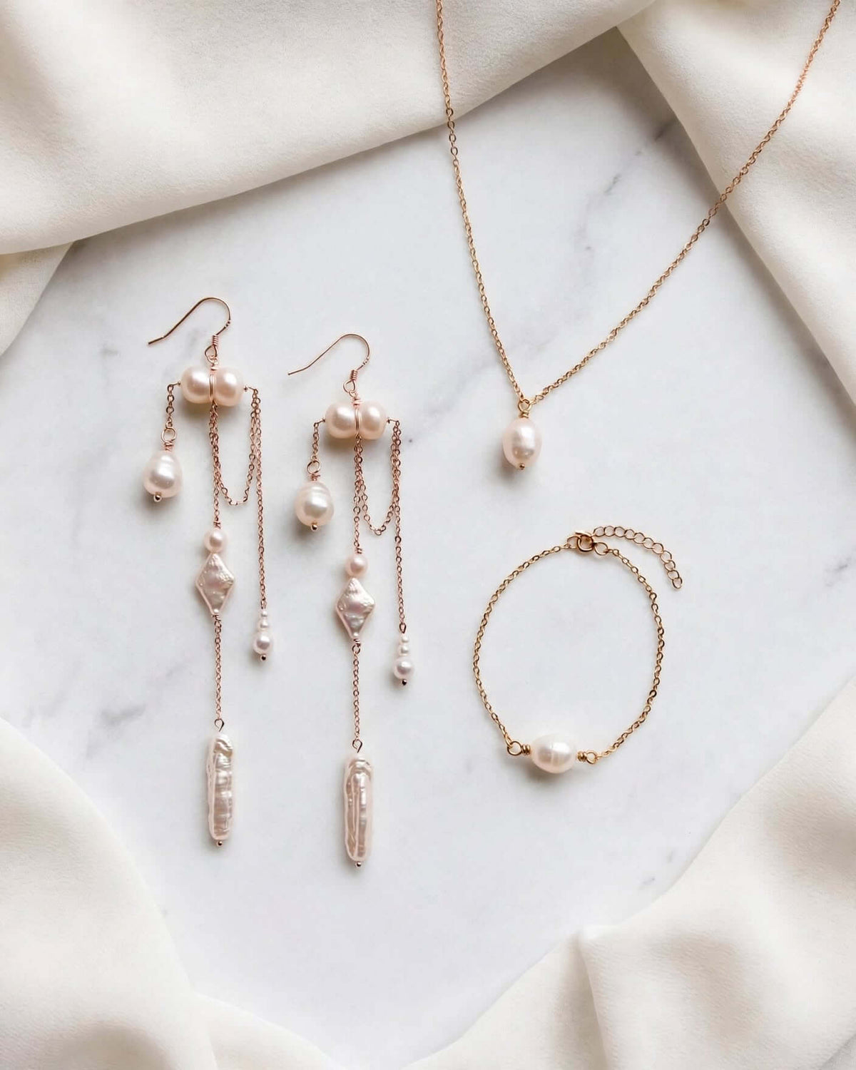 Close up of gold chain pearl drop earrings with teardrop and stick baroque pearls for bride