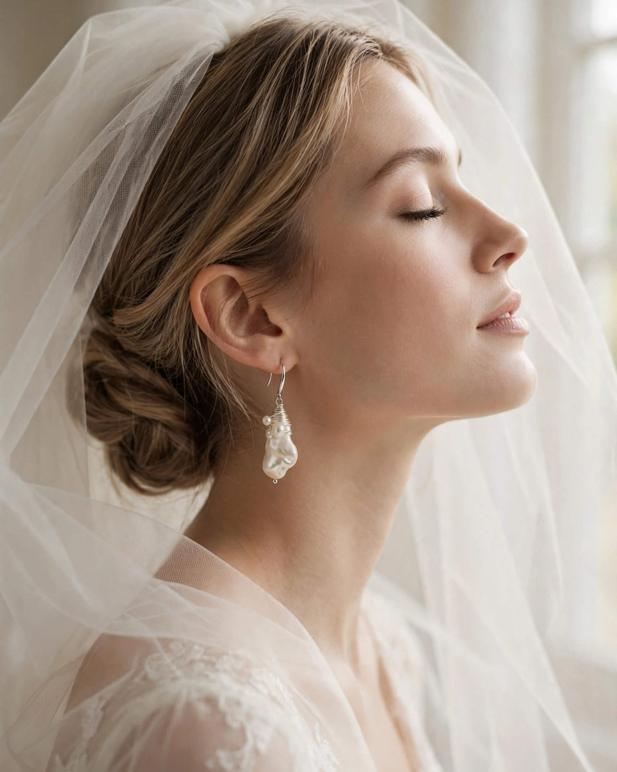 bride wearing baroque pearl dangle earrings paired with sheer wedding veil