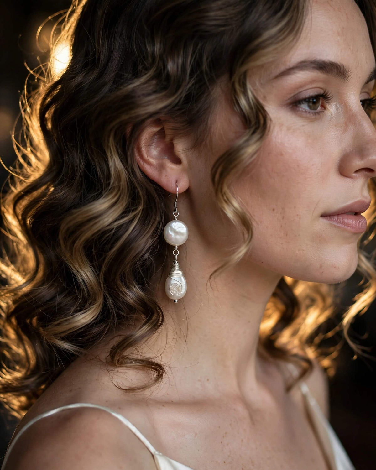 side profile of bride showing freshwater pearl drop earrings in wedding hairstyle