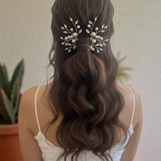 Delicate pearl bridal hairpiece with crystal accents, photographed on white satin fabric.