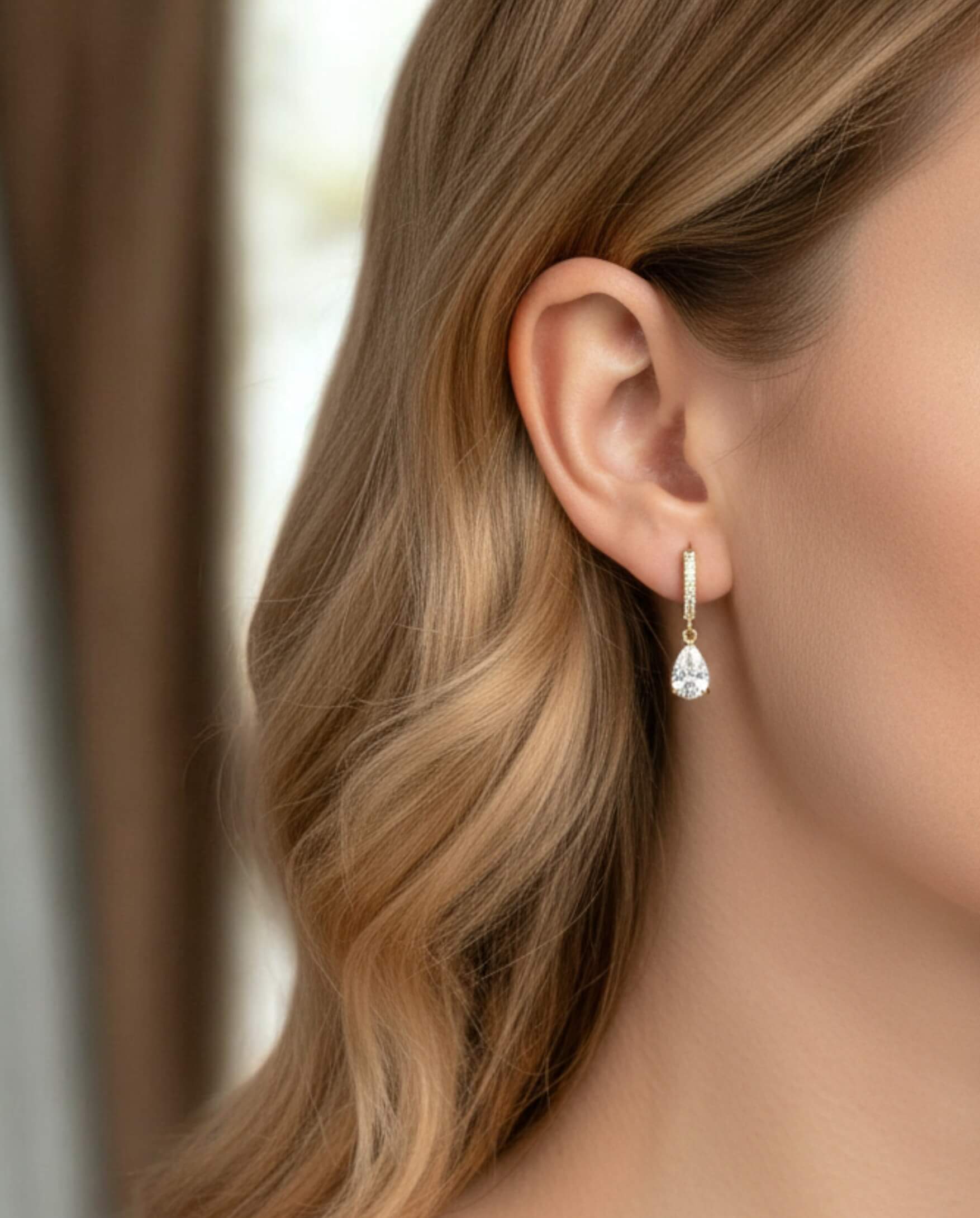 Close-up of a woman wearing a teardrop earring with a blurred background