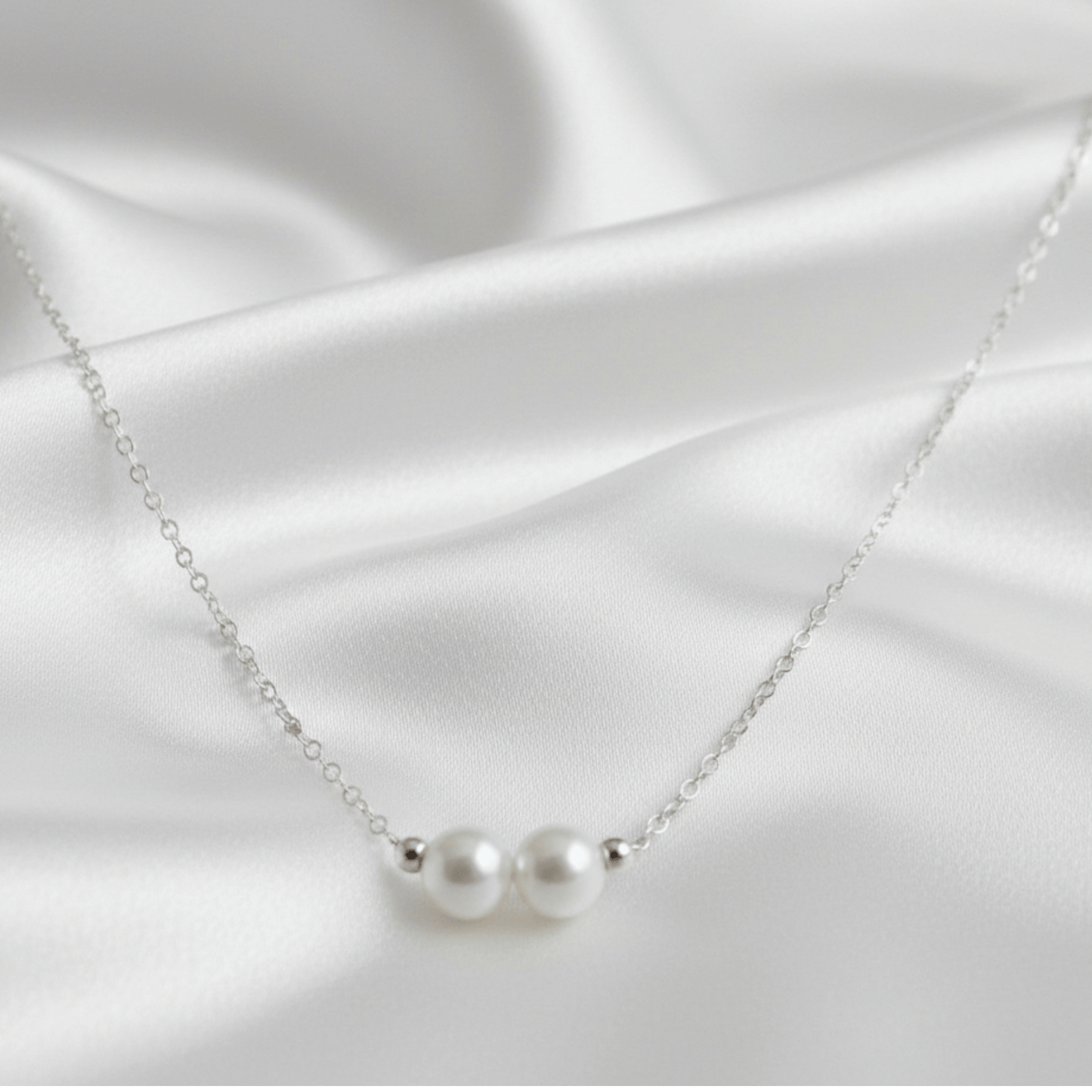Pearl necklace on a white satin background