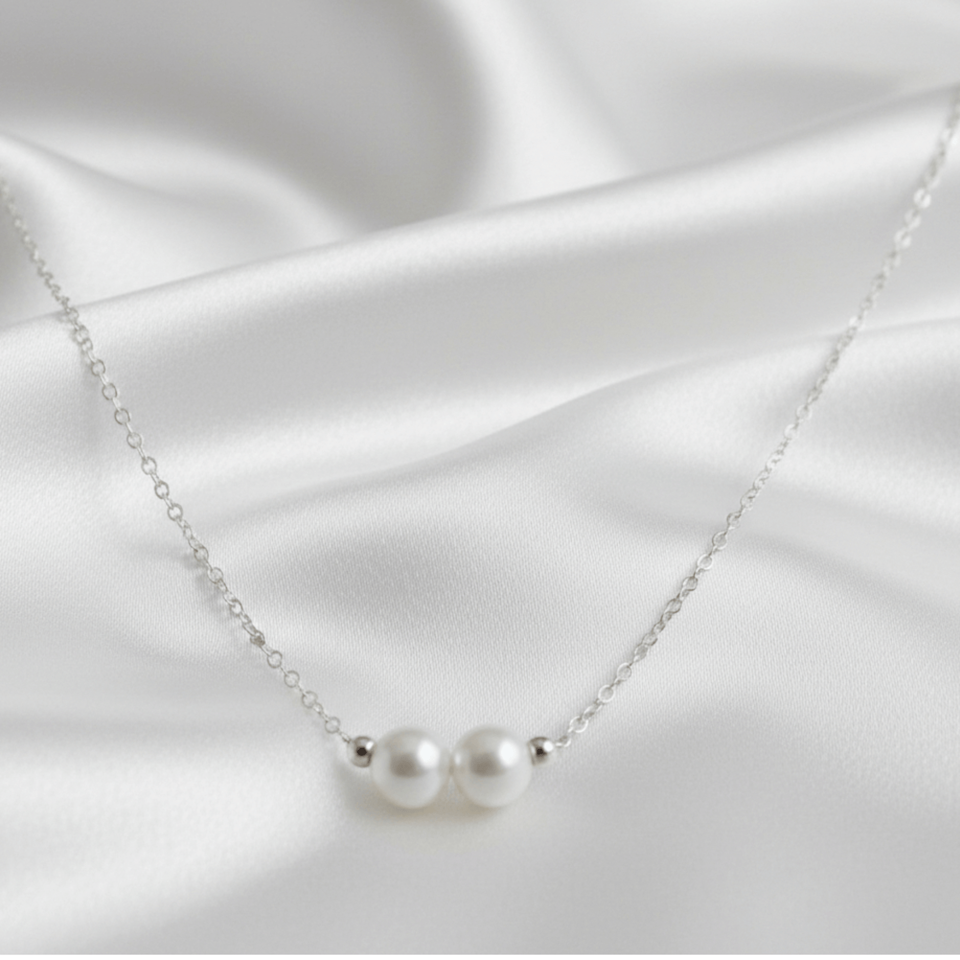 Pearl necklace on a white satin background